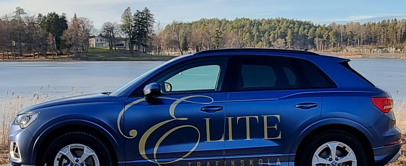 Elite Trafikskolas Audi parkerad framför sjö